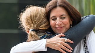 Smiling woman hugging teenager girl